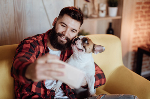 bearded man taking a selfie with his dog